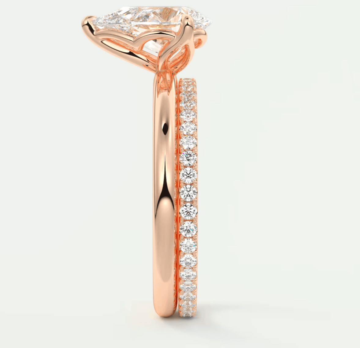 Rose gold diamond engagement ring with a princess cut center stone and pave set side stones.