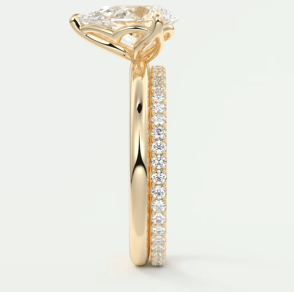 18k yellow gold engagement ring with a pear-shaped diamond and pavé set diamonds on the band.