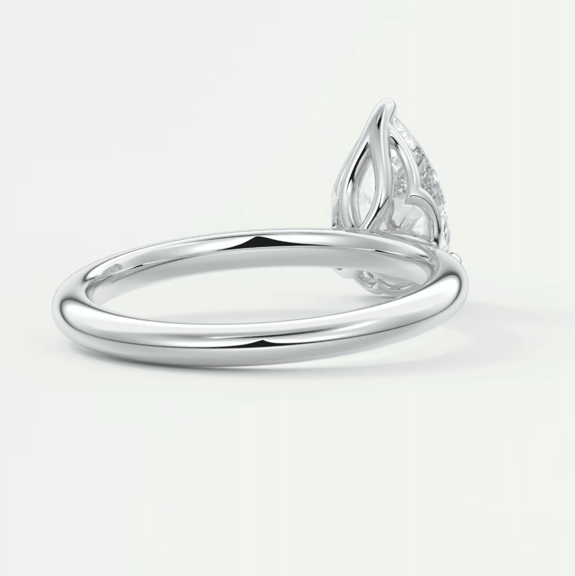 White gold diamond engagement ring with a marquise-cut stone and intricate leaf design on the band.