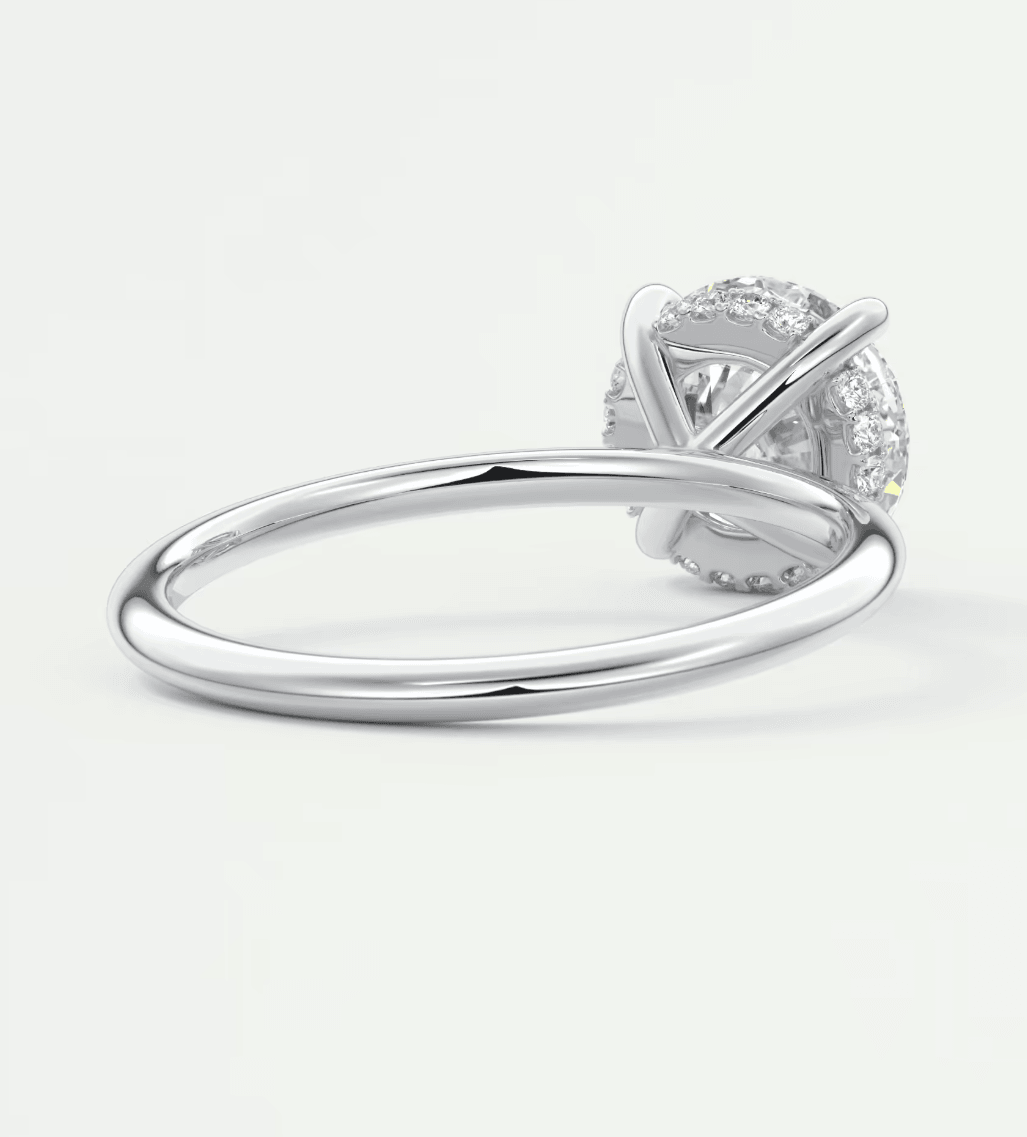 18-karat white gold diamond engagement ring with a round-cut center stone and halo of smaller diamonds.