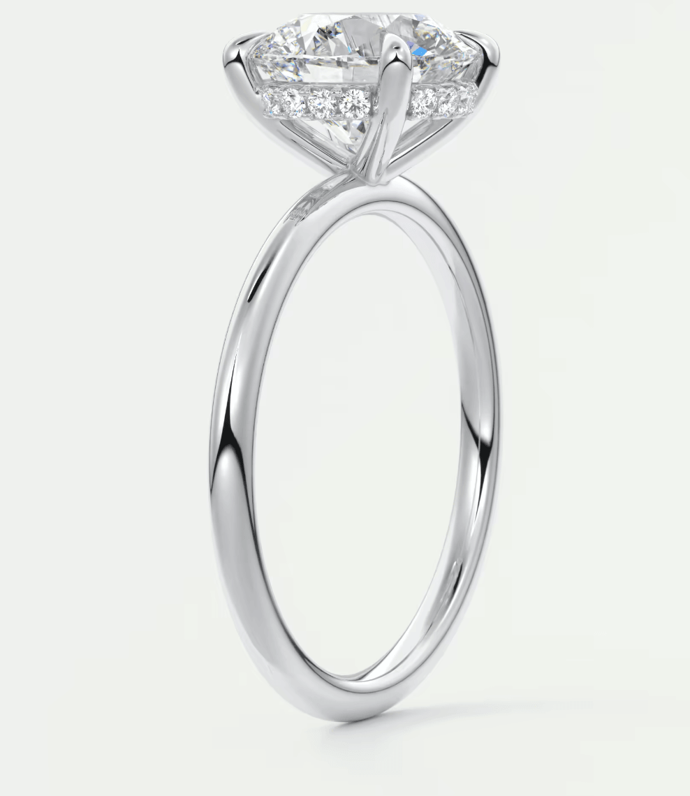 18-karat white gold engagement ring with a marquise-cut diamond and small accent diamonds.