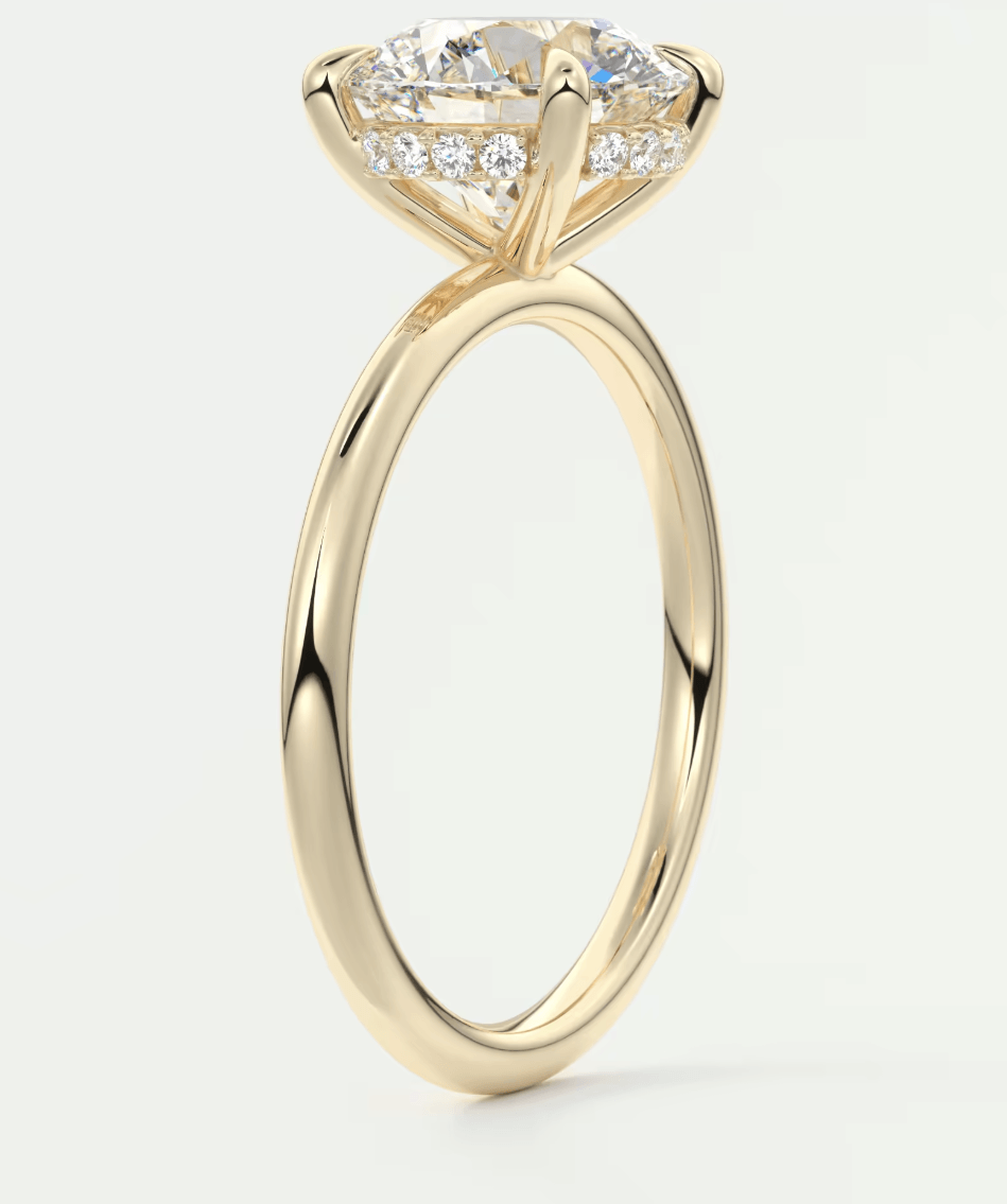 18k yellow gold engagement ring with a cushion-cut diamond and pavé side stones.
