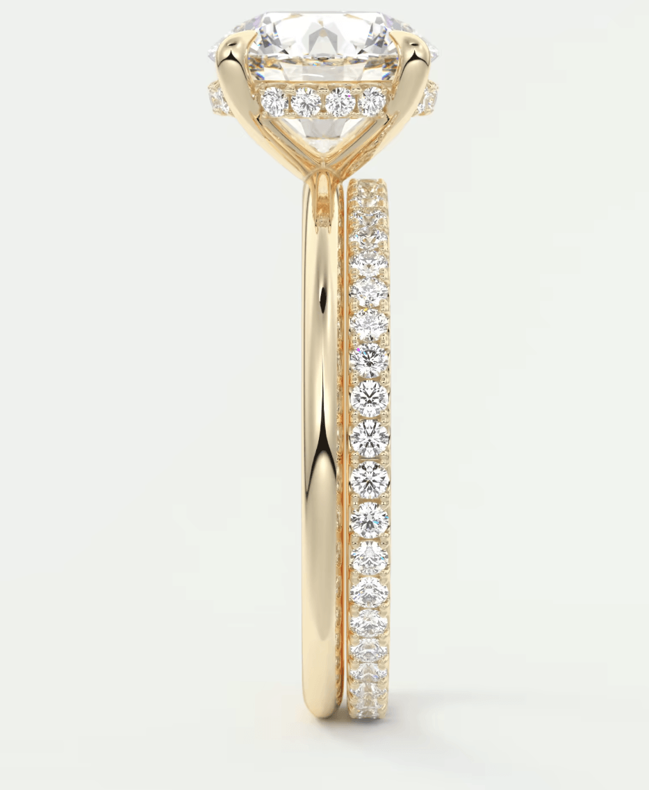 18k yellow gold engagement ring with a cushion-cut diamond and pavé set diamonds on the band.