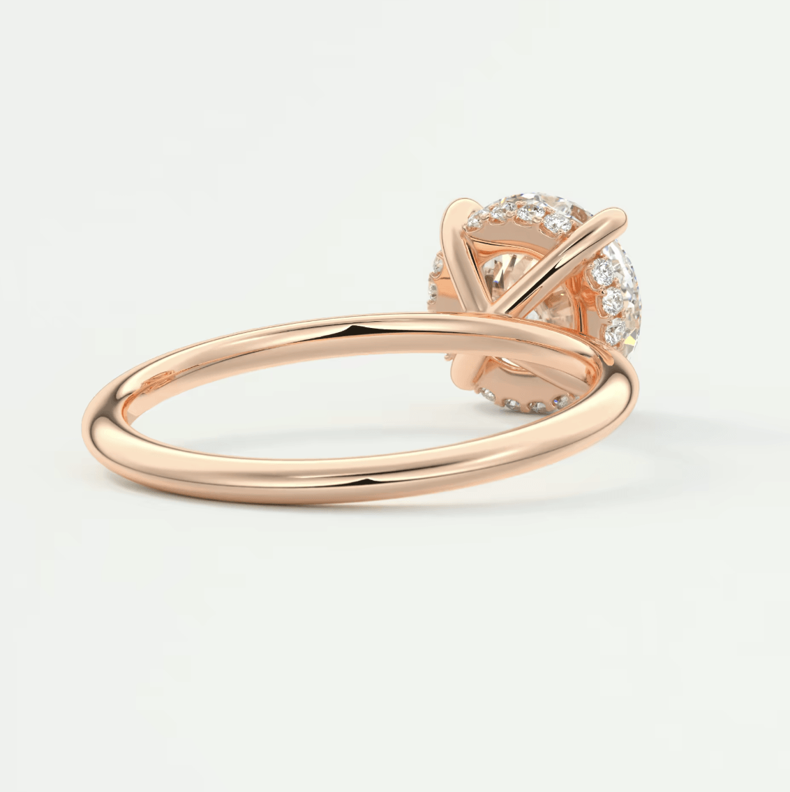 Rose gold diamond engagement ring with a round-cut center stone and halo of smaller diamonds.