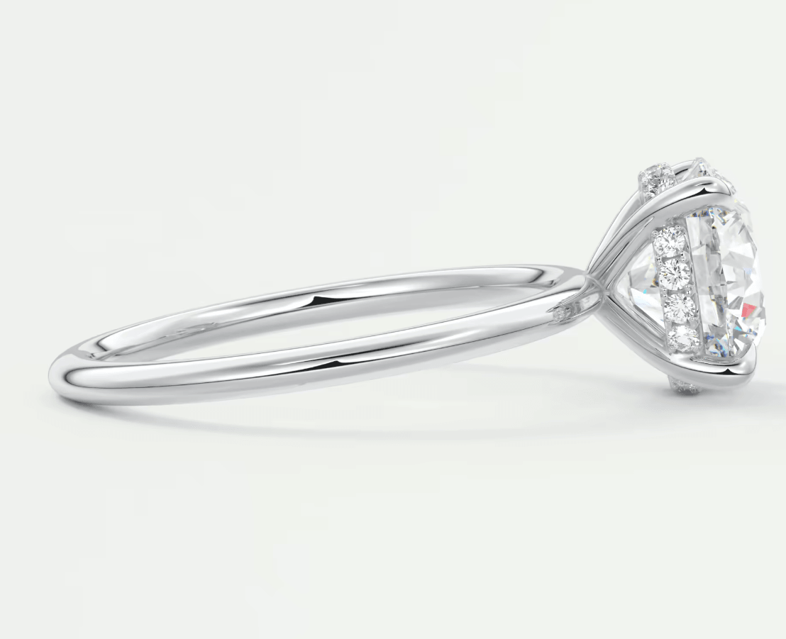 18-karat white gold engagement ring with a round diamond center and smaller diamonds on the band.