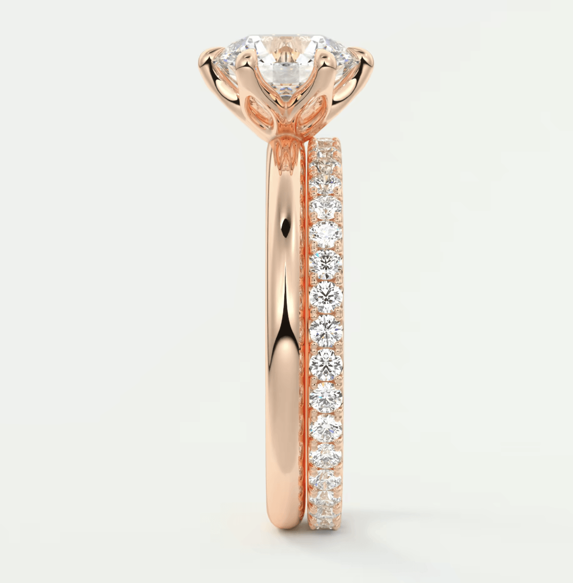 18-karat rose gold engagement ring with a round diamond center and pavé-set diamonds on the band.