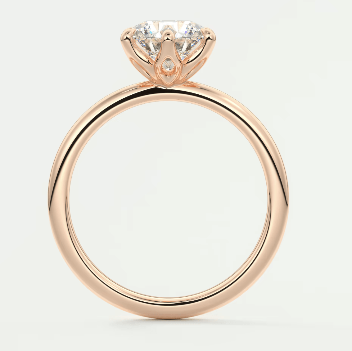 18-karat rose gold engagement ring with a round diamond.
