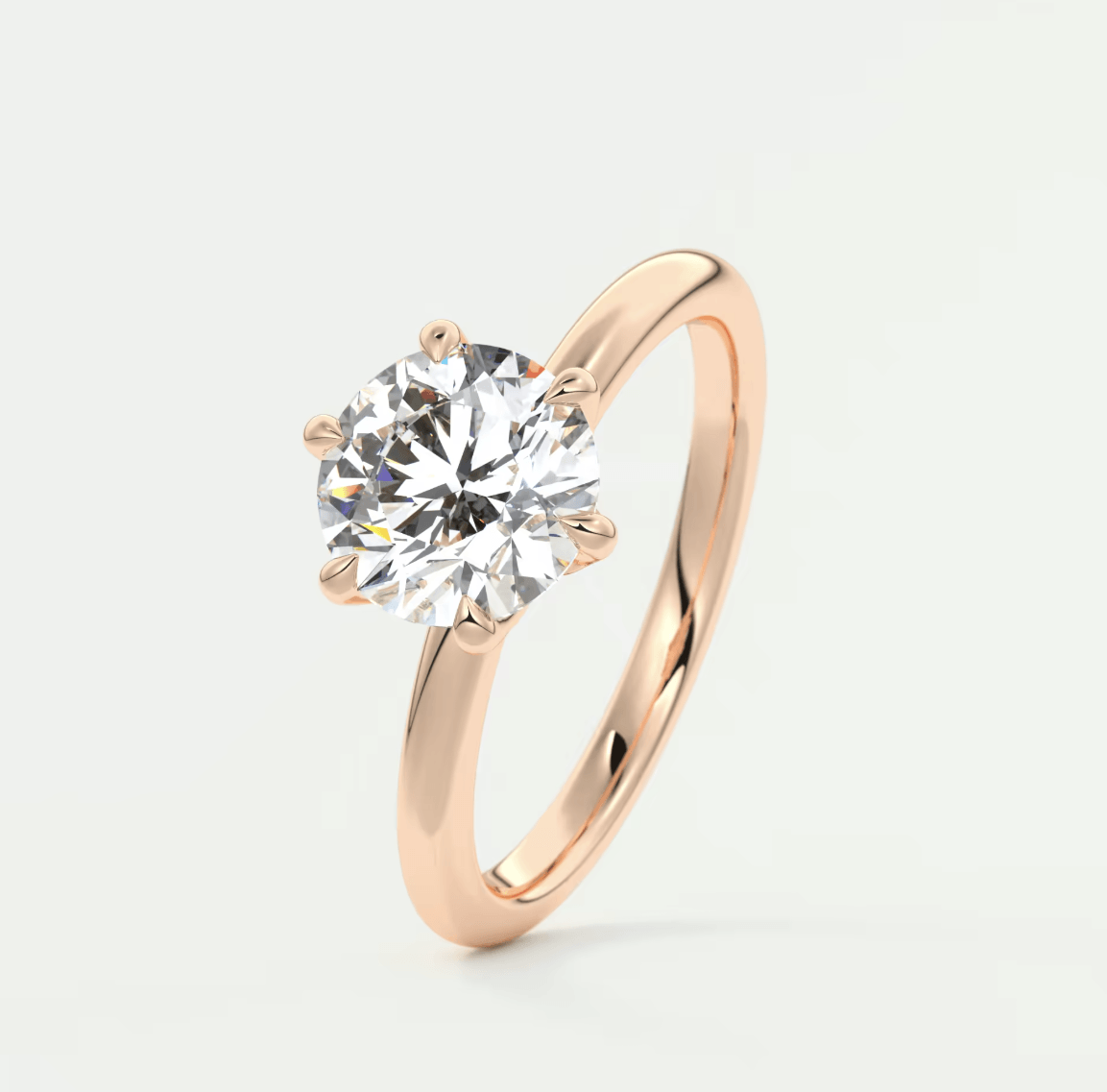 18-karat rose gold solitaire diamond engagement ring.