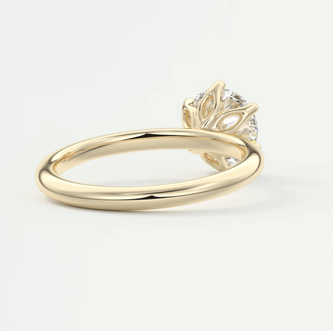 18k yellow gold engagement ring with a diamond center stone and leaf-inspired band design.