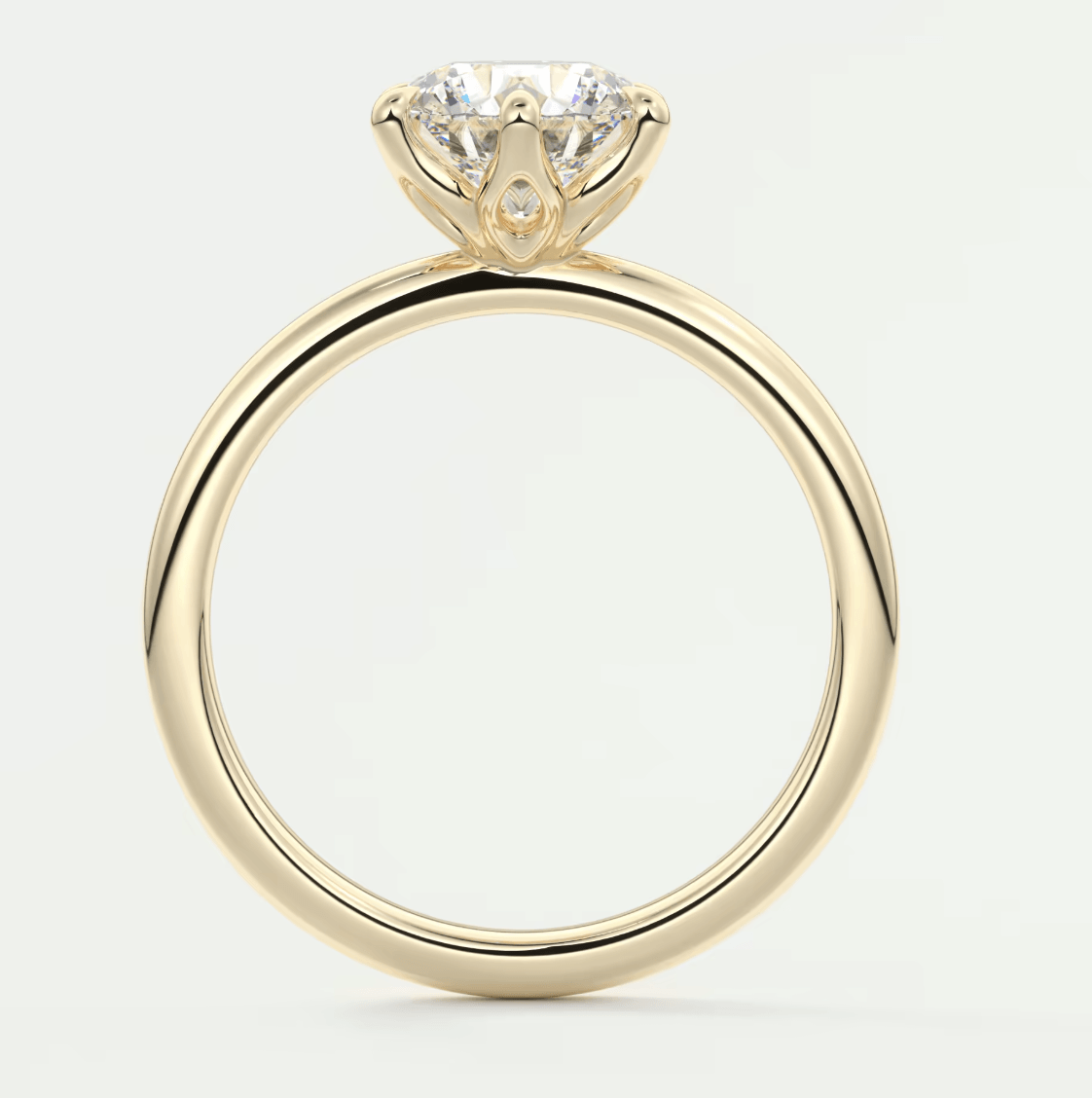 18-karat yellow gold engagement ring with a round diamond center stone.