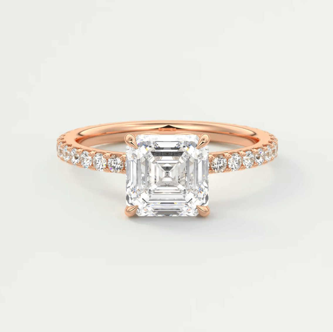 18k rose gold engagement ring with an asscher-cut diamond and pave set diamonds on the band.