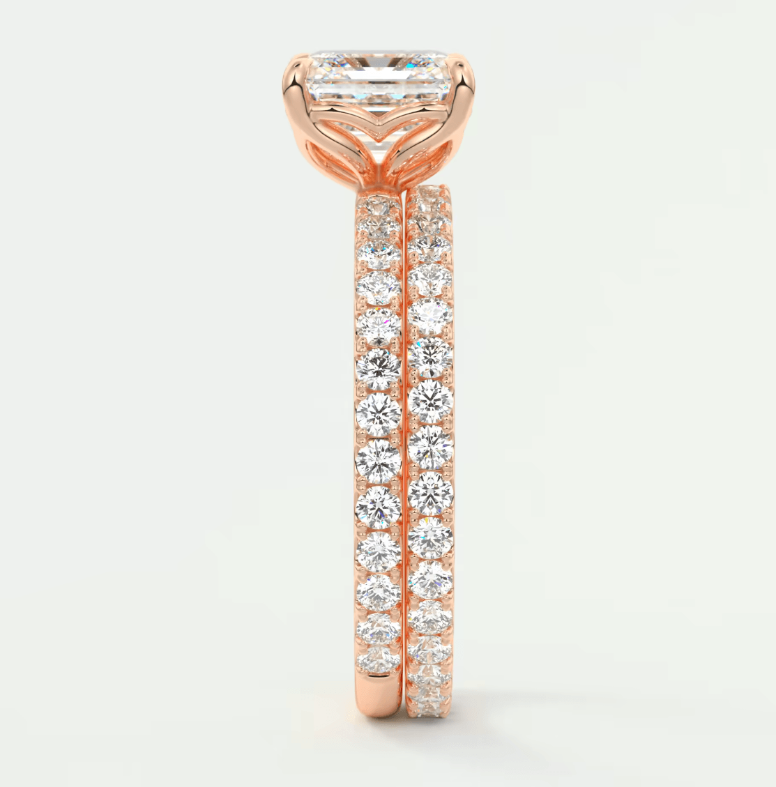 18k rose gold engagement ring with a princess cut diamond and pave set diamonds on the band.