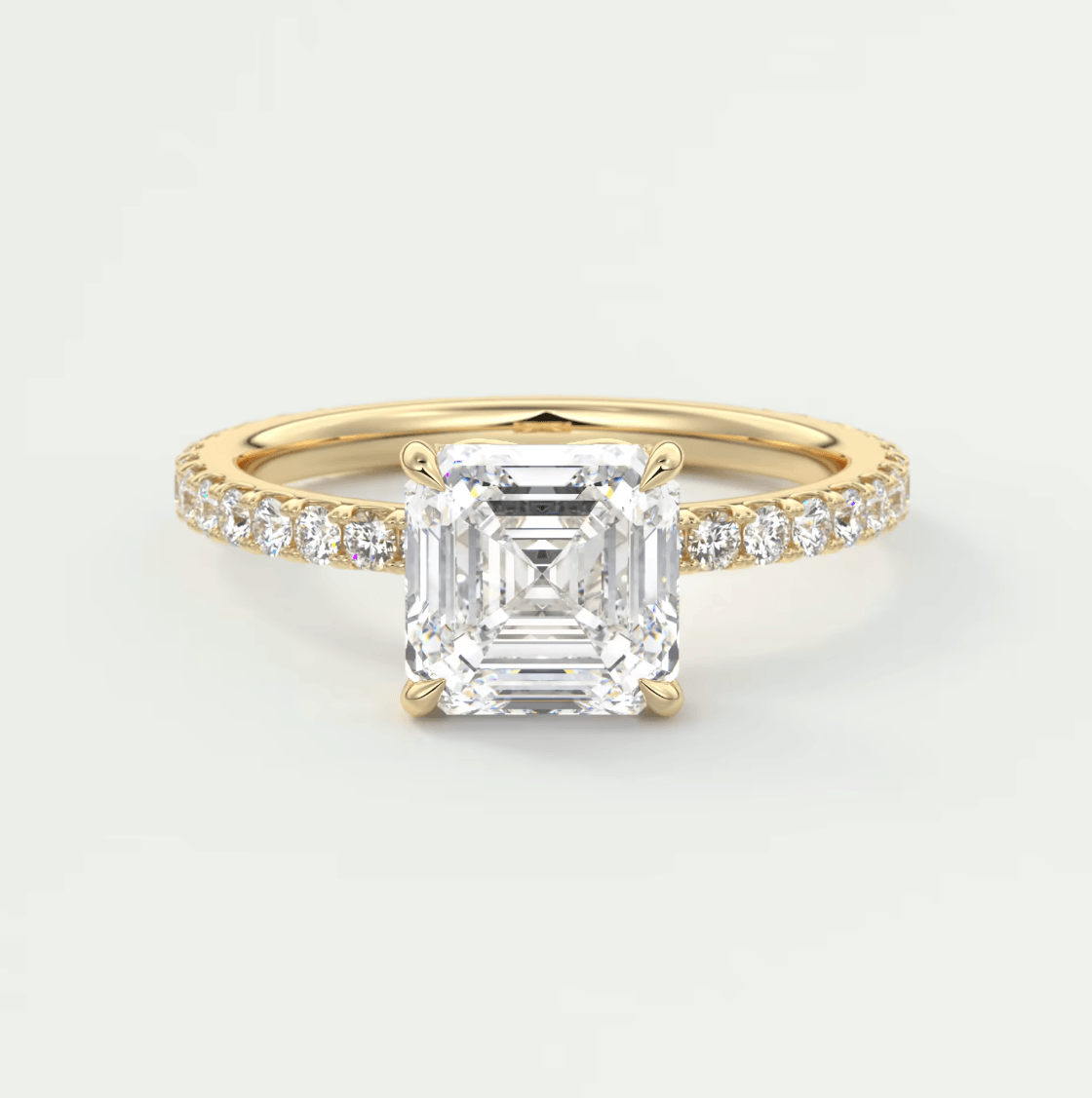 18k yellow gold engagement ring with an asscher-cut diamond and pave-set diamonds on the band.