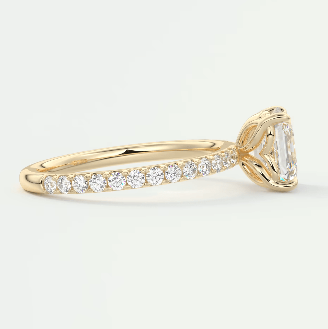 18k yellow gold diamond engagement ring with an emerald-cut center stone and pave-set diamonds on the band.