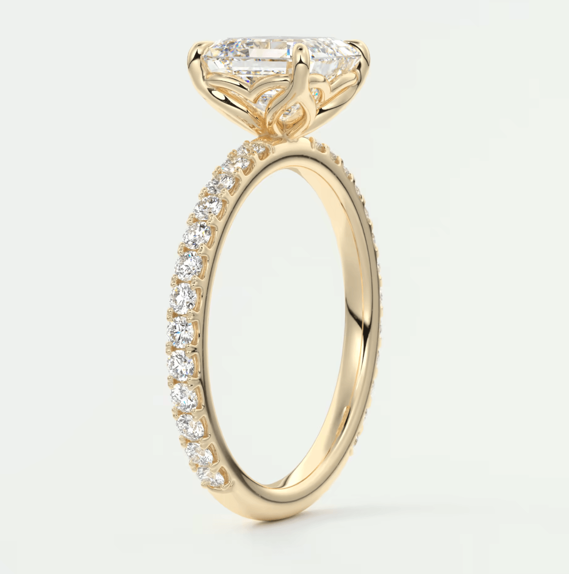 18k yellow gold engagement ring with a princess cut diamond and pavé side stones.