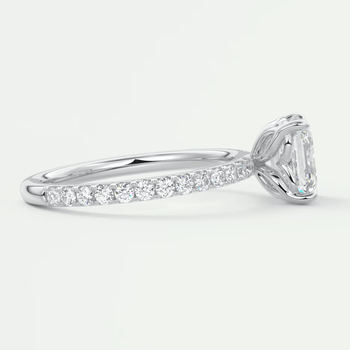 18k white gold diamond engagement ring with an emerald-cut center stone and pave-set diamonds on the band.