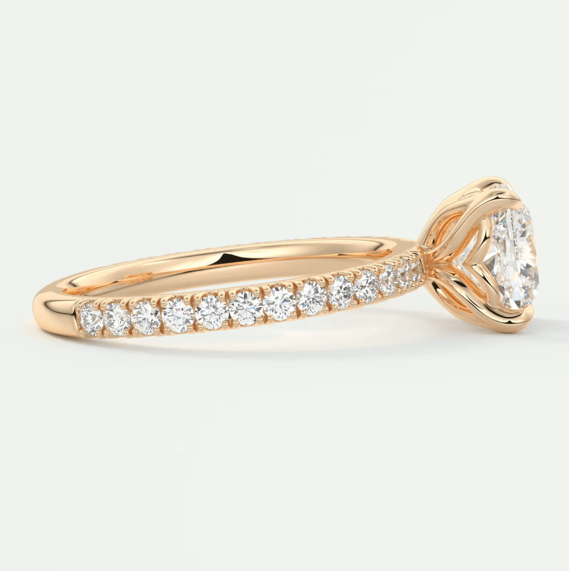18k rose gold diamond engagement ring with a cushion-cut center stone and pave set diamonds on the band.