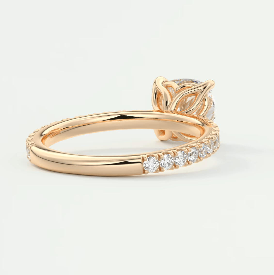 18k rose gold diamond engagement ring with a leaf-inspired band and pave set diamonds.