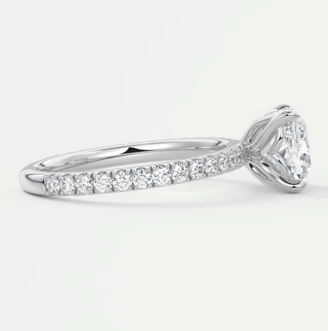 18k white gold diamond engagement ring with a cushion-cut center stone and pave set diamonds on the band.
