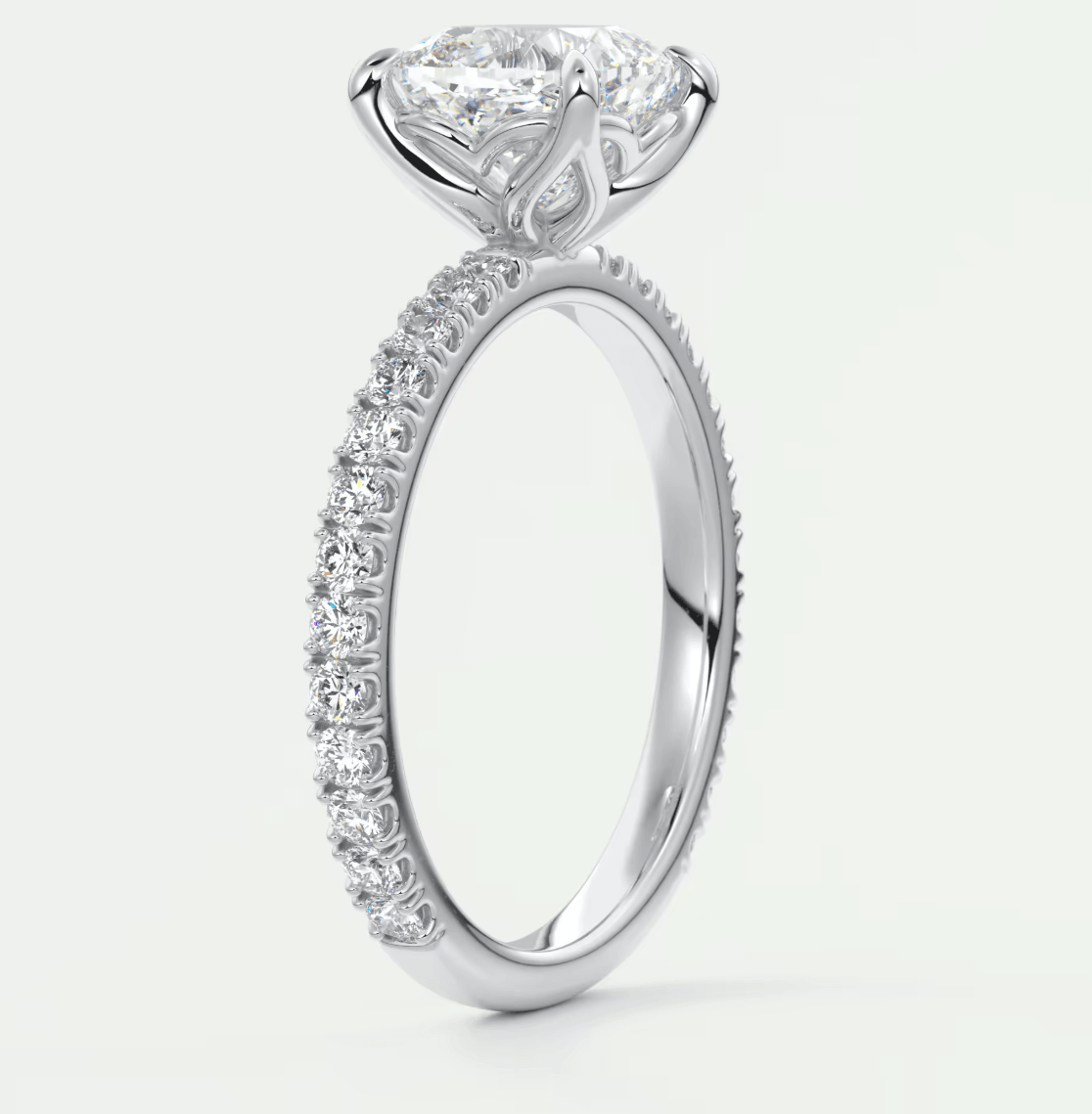 18-karat white gold engagement ring with a princess-cut diamond center stone and pavé-set diamonds on the band.