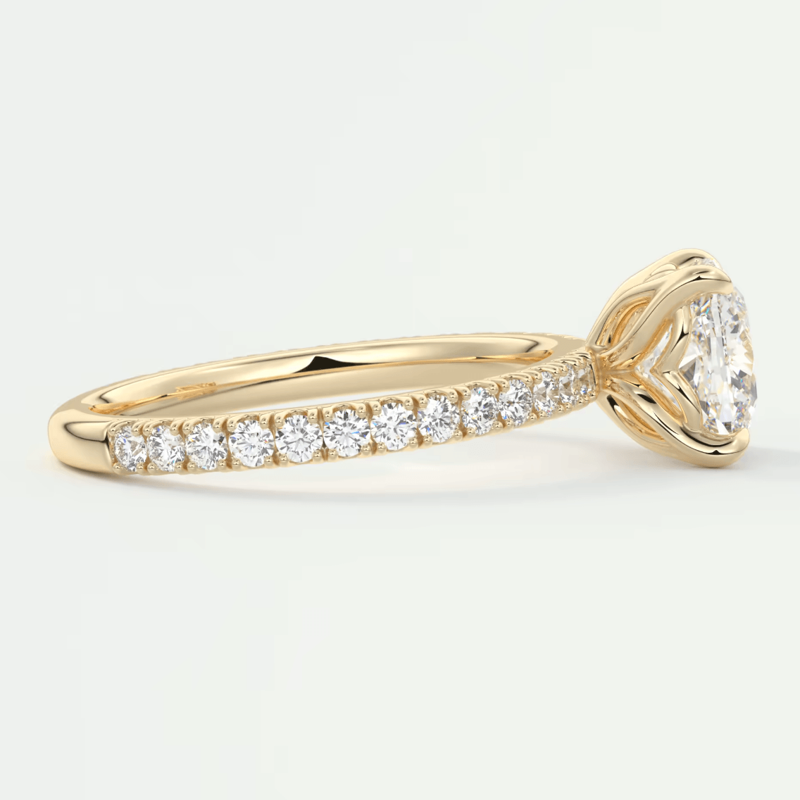 18k yellow gold diamond engagement ring with a cushion-cut center stone and pavé set diamonds on the band.