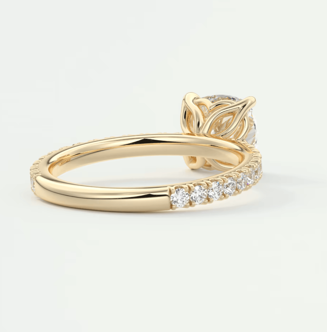 18k yellow gold diamond engagement ring with a leaf motif and pave set diamonds on the band.