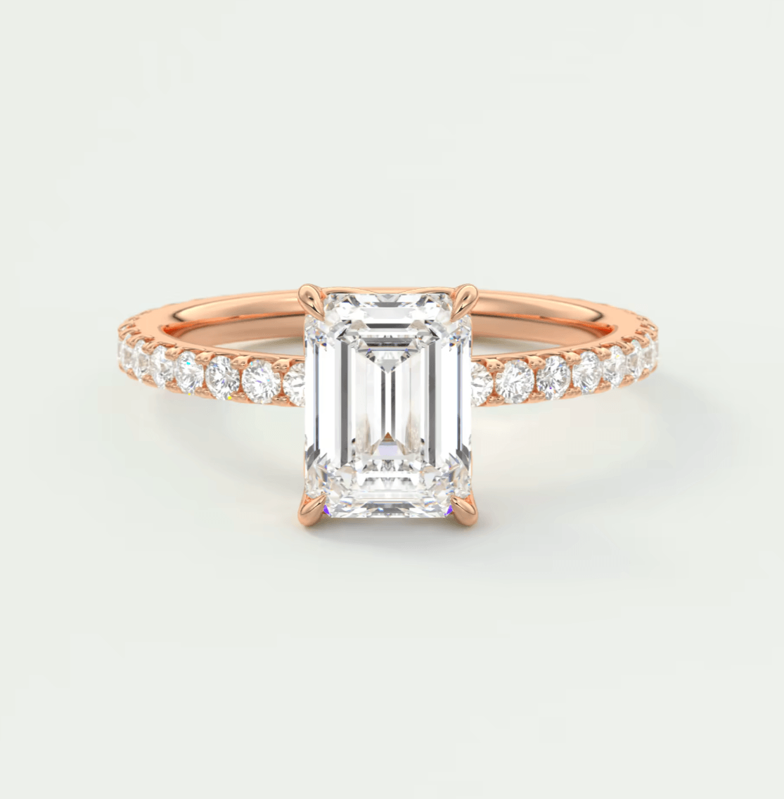 18k rose gold emerald cut diamond engagement ring with a pave band.