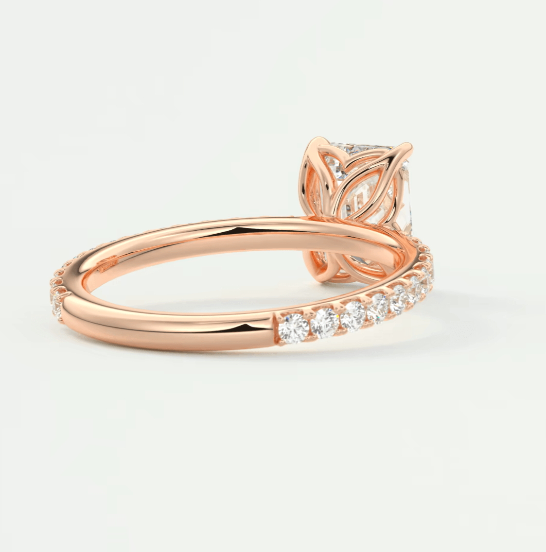 18k rose gold engagement ring with a princess cut diamond and pave set diamonds on the band.