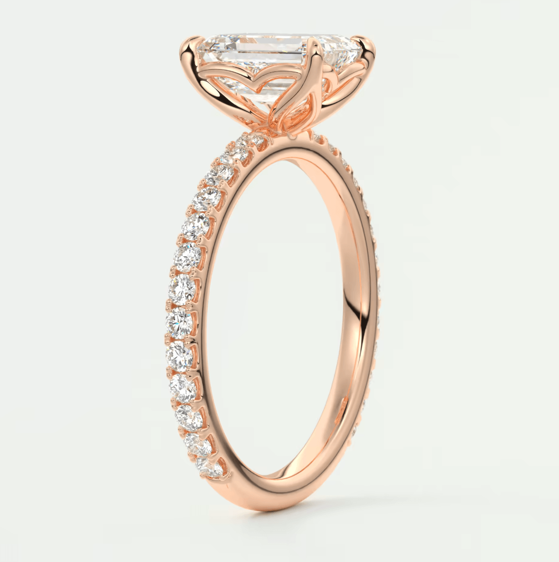 18k rose gold engagement ring with a marquise-cut diamond and pavé set diamonds on the band.