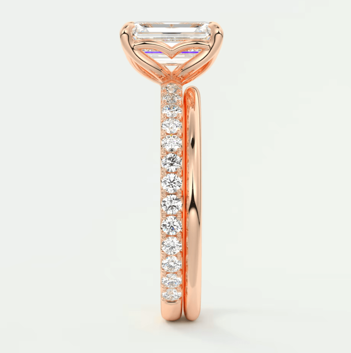 18k rose gold engagement ring with emerald cut diamond and pave set diamonds on band.