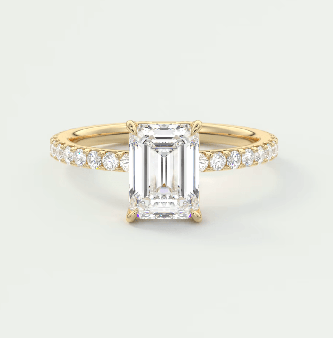 18k yellow gold emerald-cut diamond engagement ring with a channel-set band.