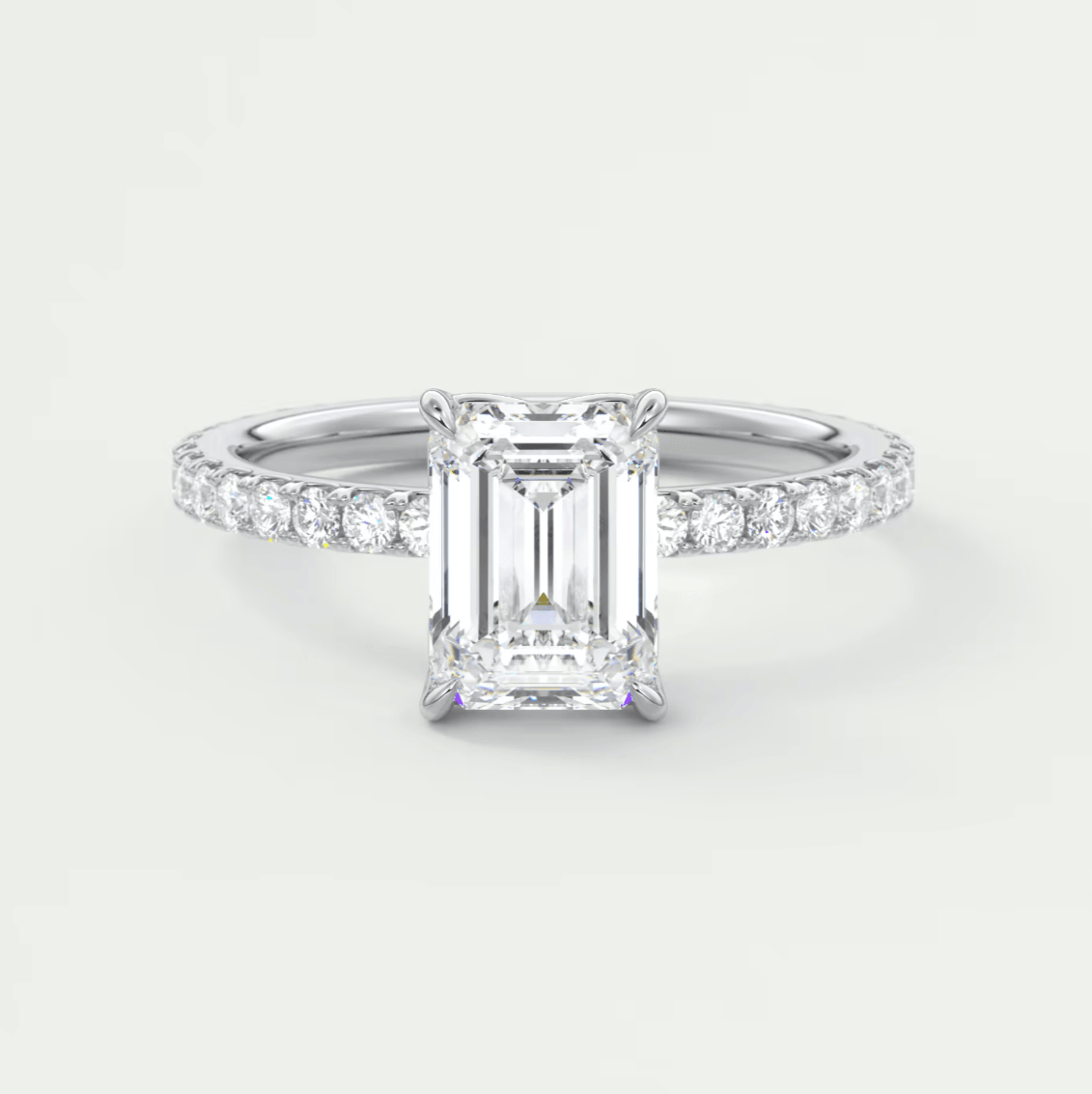 18k white gold emerald cut diamond engagement ring with a pavé band.