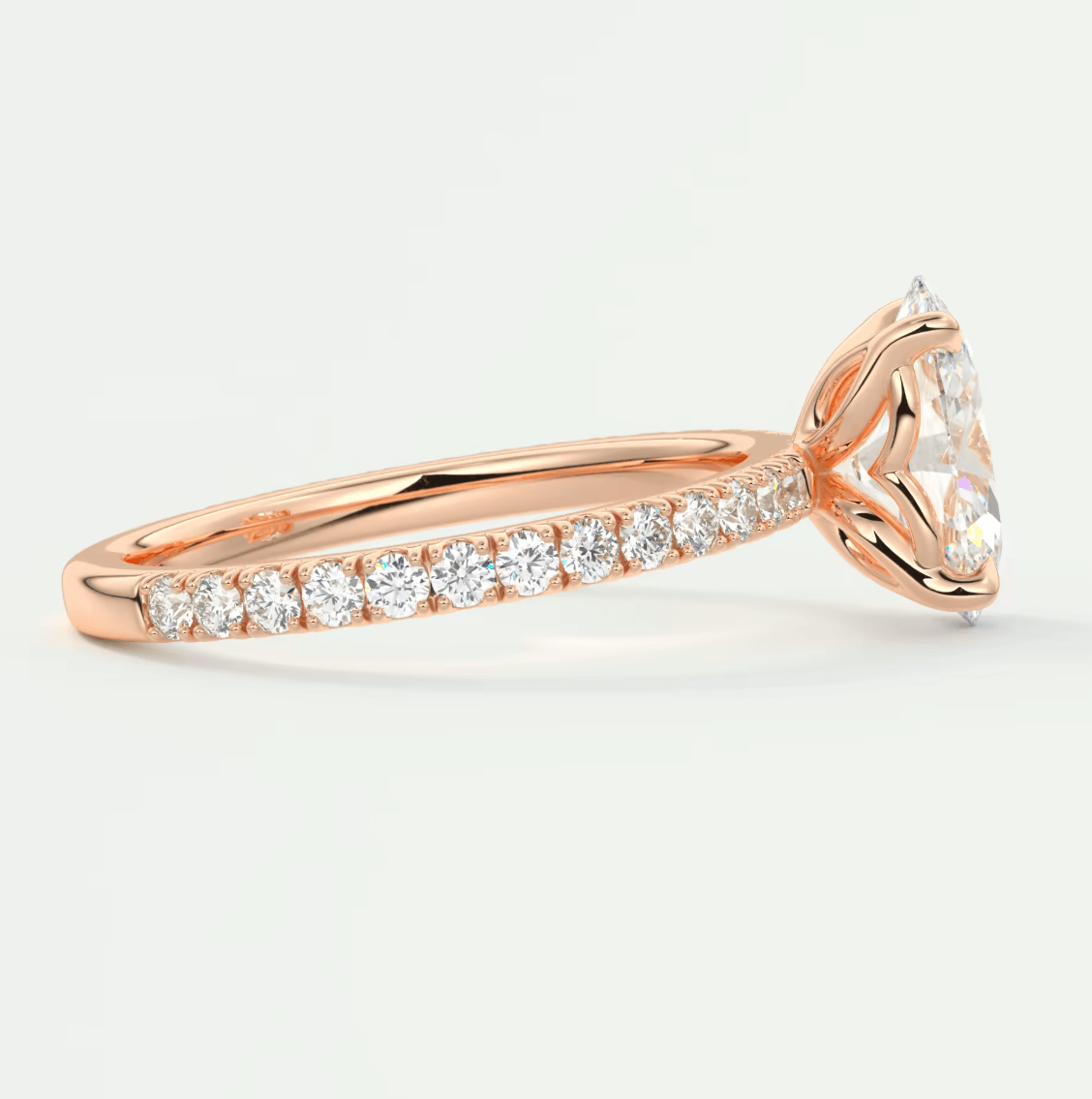 18k rose gold diamond engagement ring with a marquise-cut center stone and channel-set diamonds on the band.