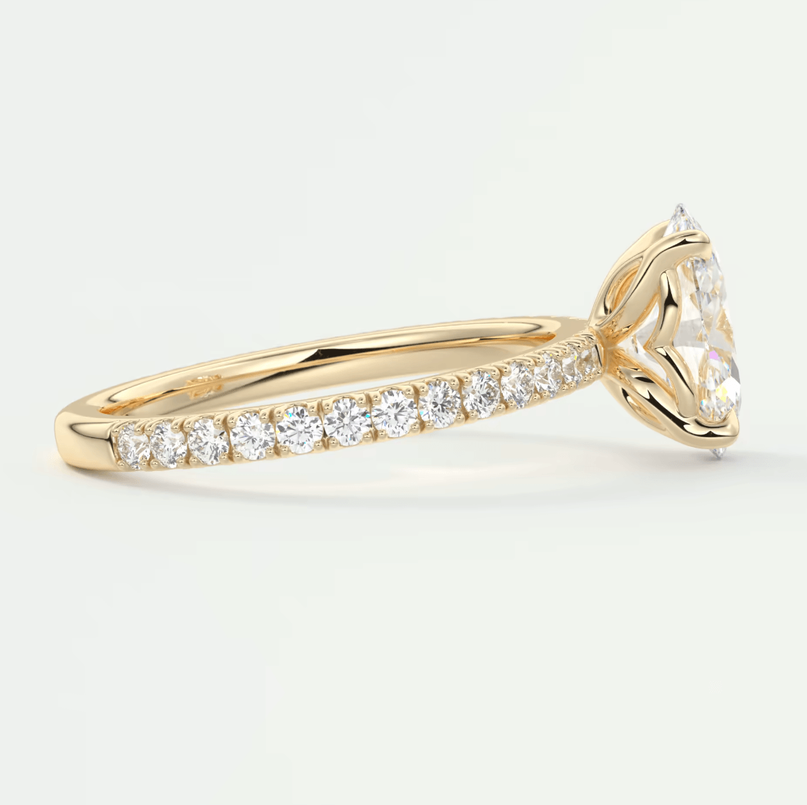 18k yellow gold diamond engagement ring with a marquise-cut center stone and pave-set diamonds on the band.