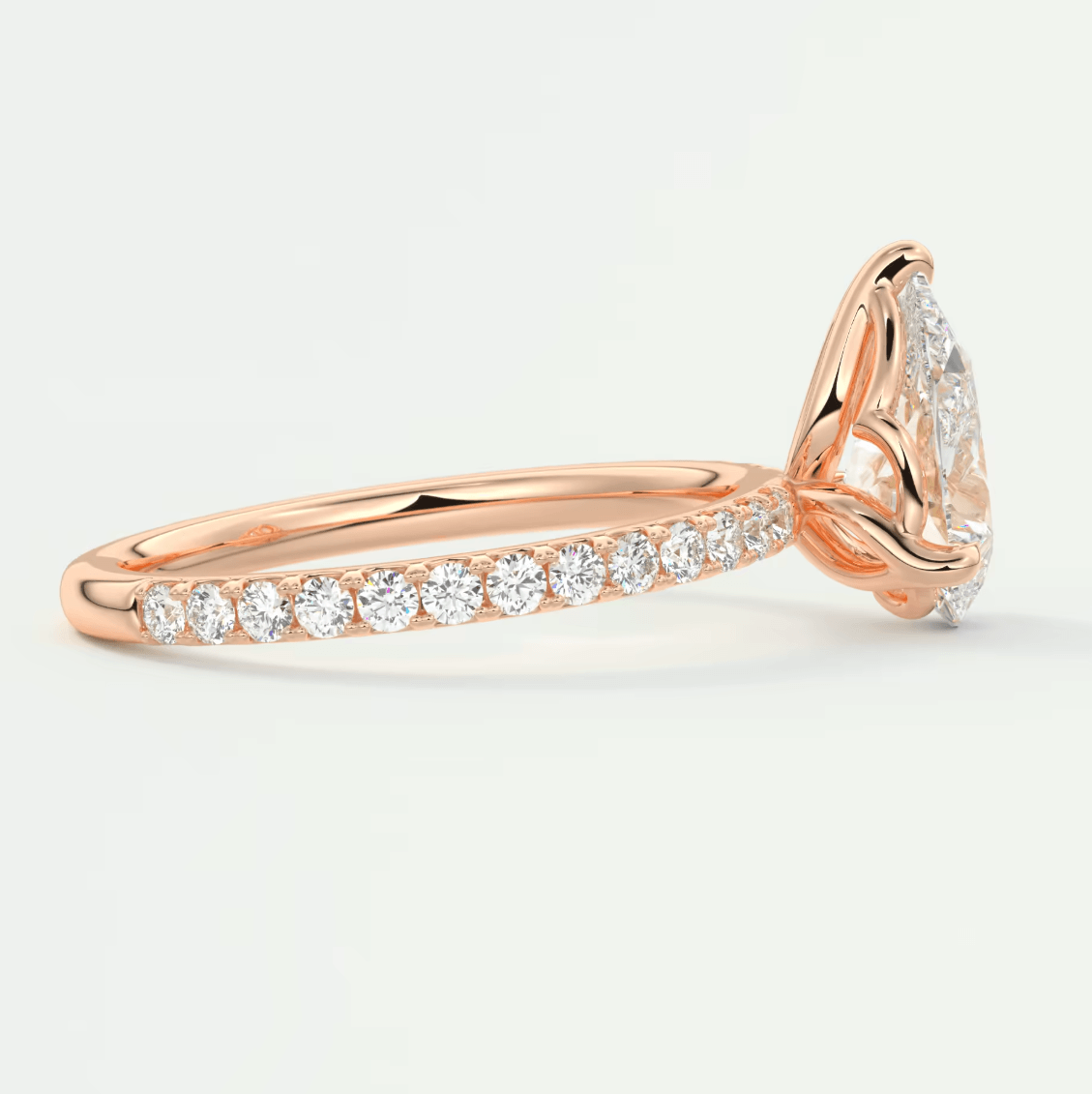 18k rose gold diamond engagement ring with a pear-shaped center stone and pavé band.