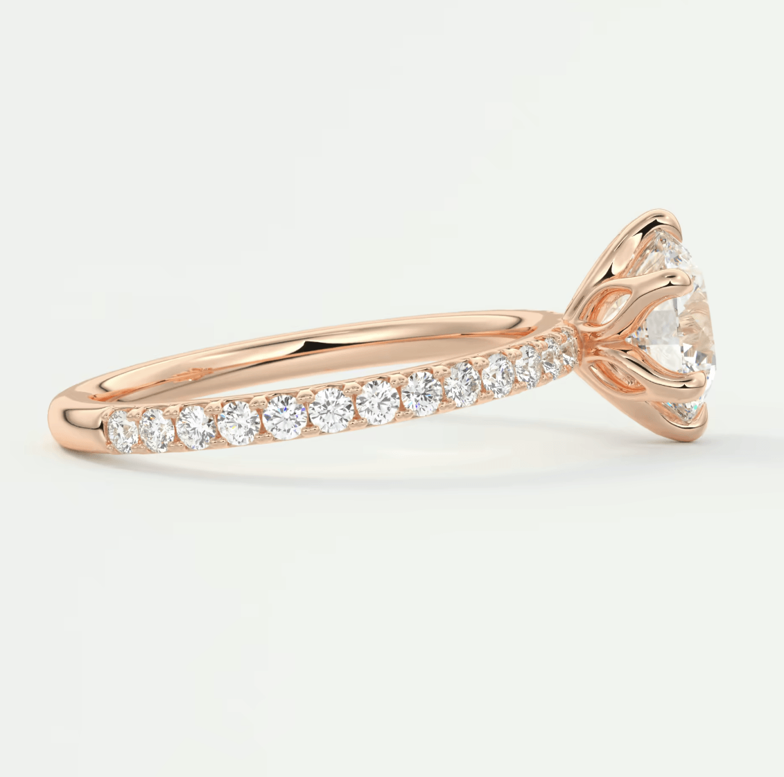 18k rose gold diamond engagement ring with a round brilliant cut center stone and pave set diamonds on the band.