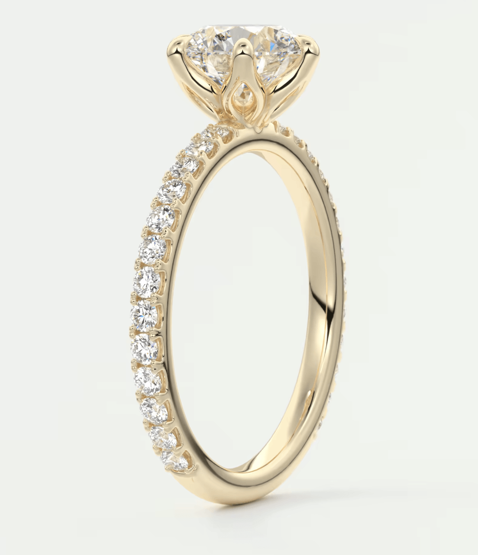 18-karat yellow gold engagement ring with a round diamond center and pavé-set diamonds on the band.