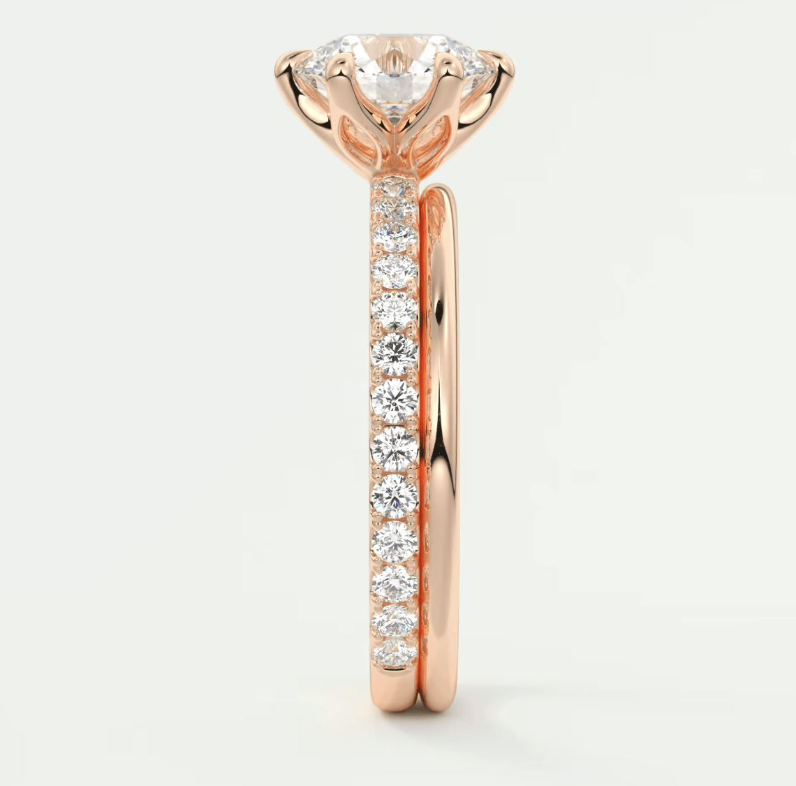 18-karat rose gold engagement ring with a round diamond center and channel-set diamonds along the band.