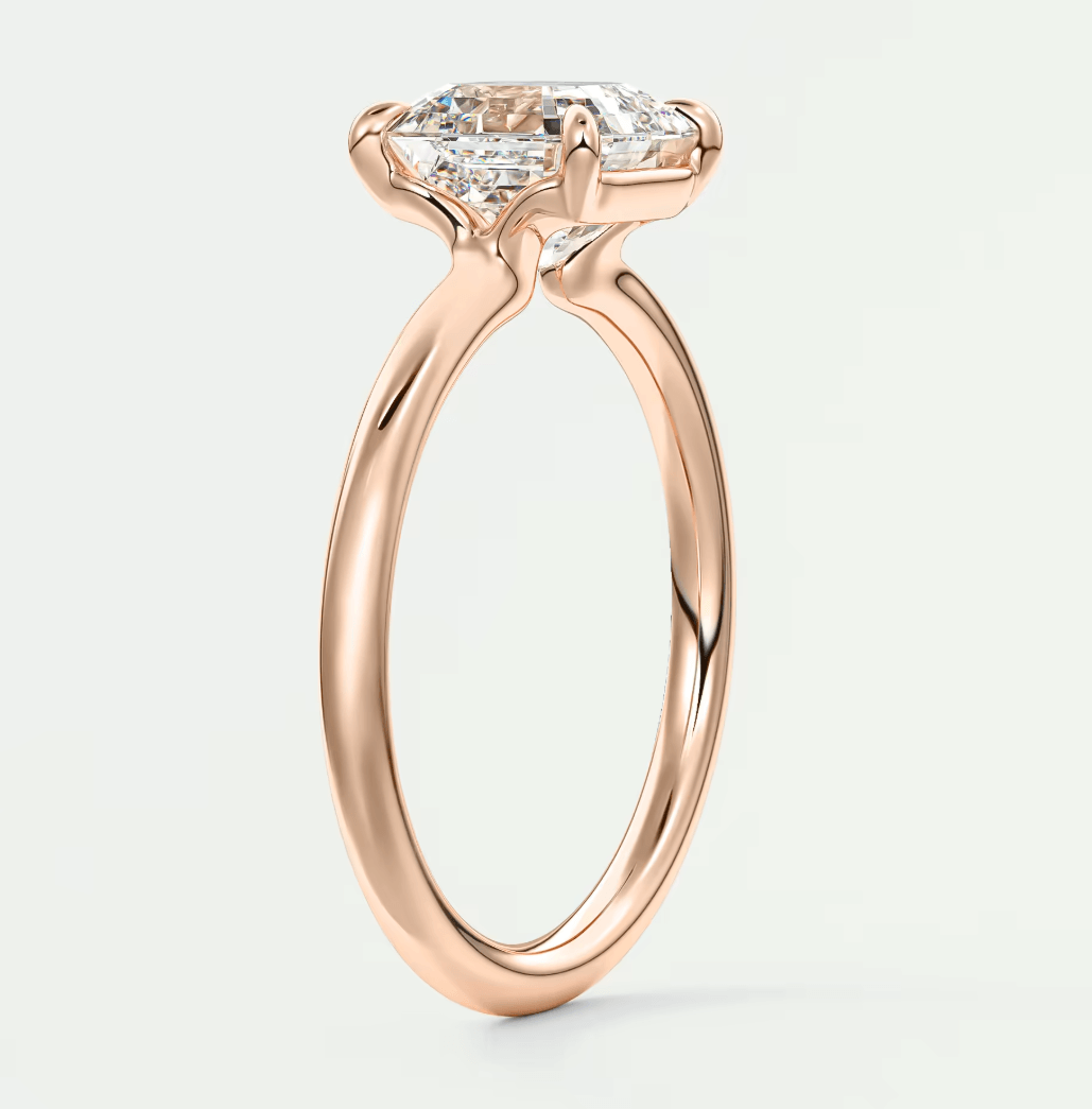 Rose gold princess cut diamond engagement ring with a twisted band design.