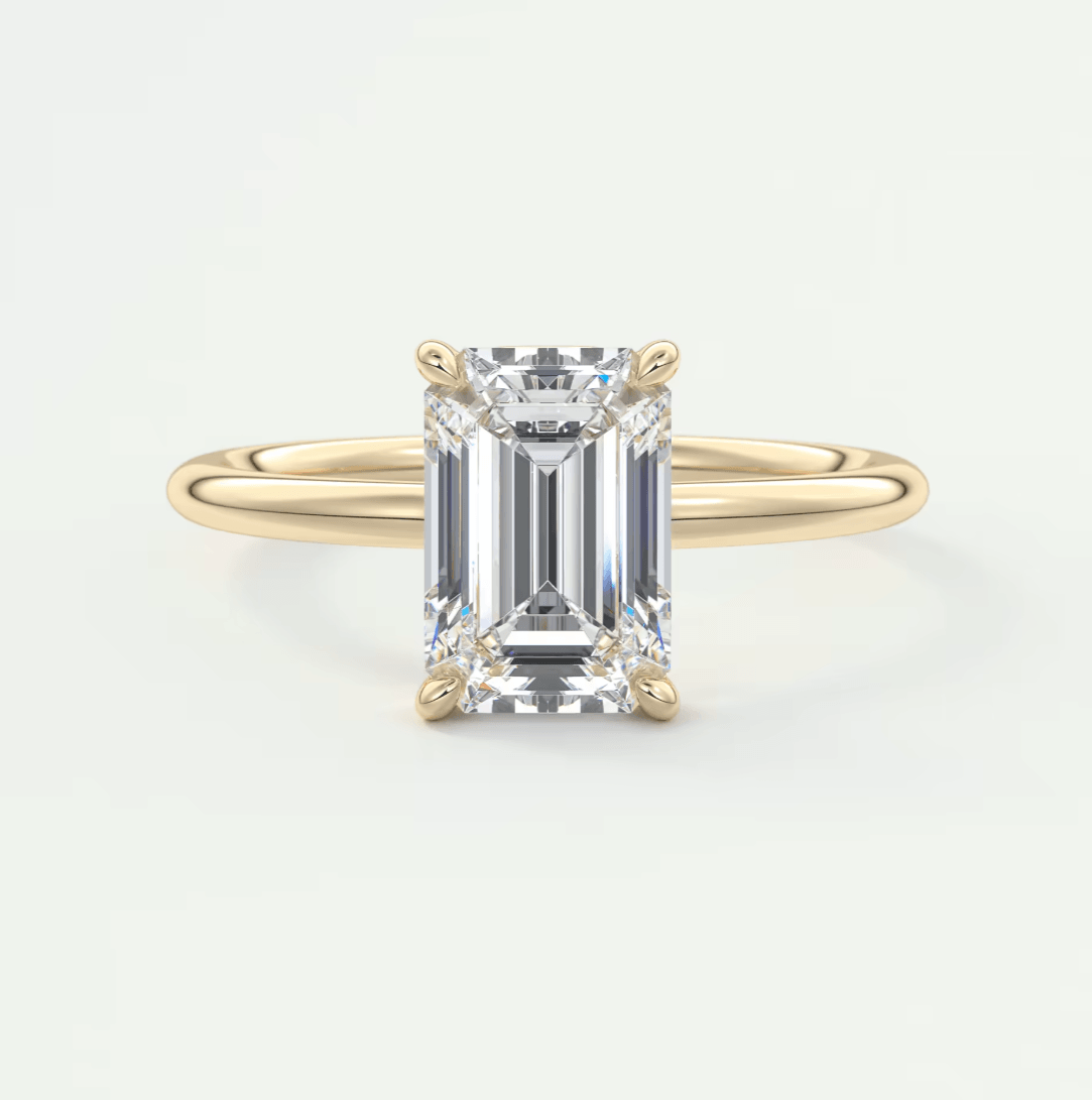 18k yellow gold emerald cut diamond engagement ring with four prongs.