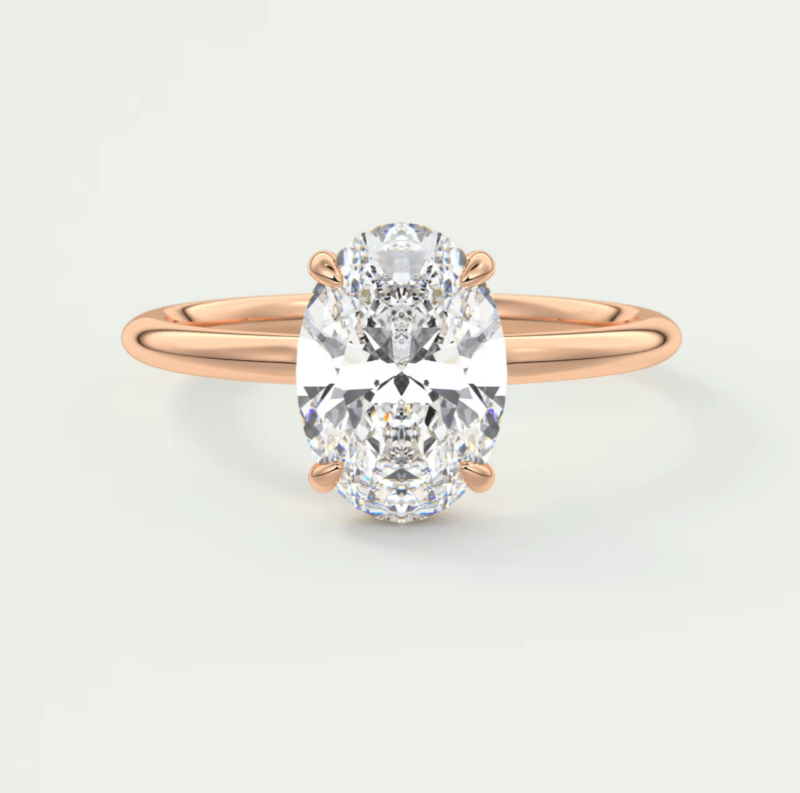 18-karat rose gold engagement ring with a cushion-cut diamond.