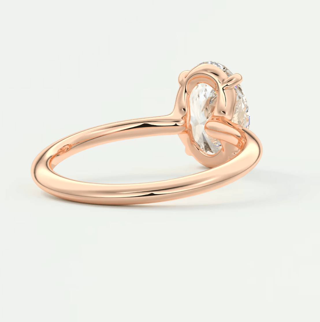 18-karat rose gold engagement ring with a cushion-cut diamond.