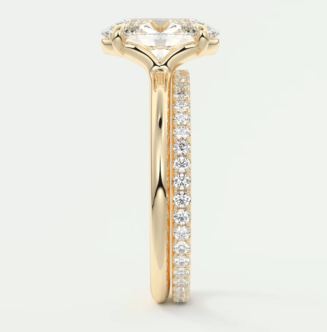 18k yellow gold engagement ring with a marquise-cut diamond and pavé side stones.