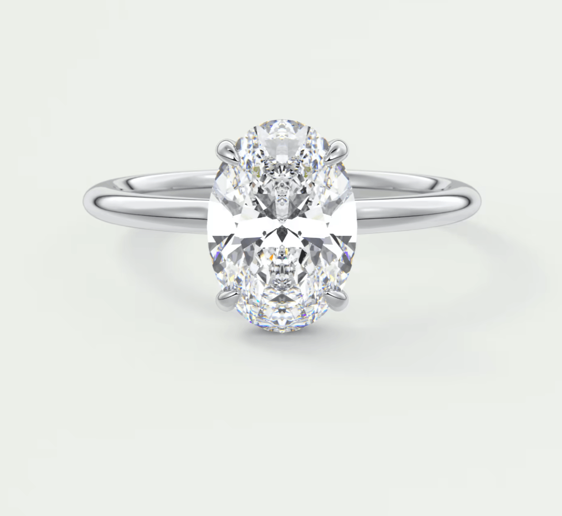 18-karat white gold oval diamond engagement ring with a solitaire setting.