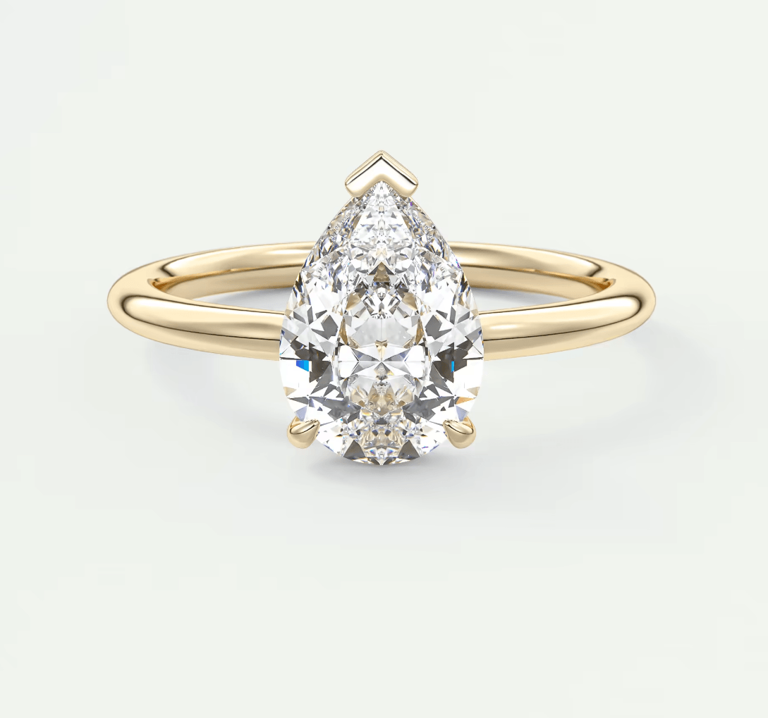 Pear-shaped diamond engagement ring with gold band, 14k yellow gold.