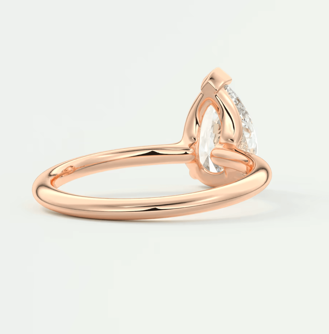 Rose gold pear-shaped diamond engagement ring with a classic solitaire design.