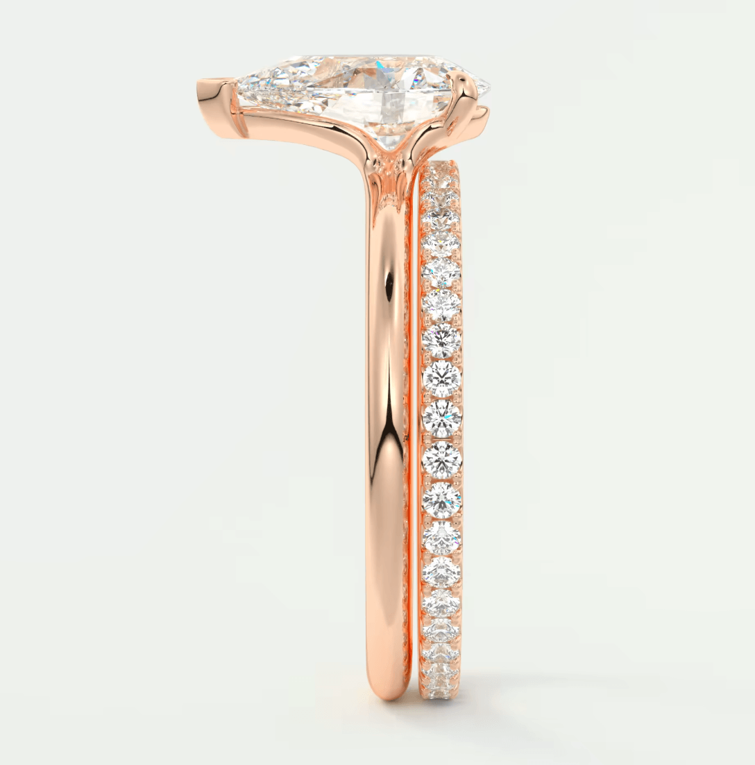 18k rose gold engagement ring with marquise diamond and pavé side stones.