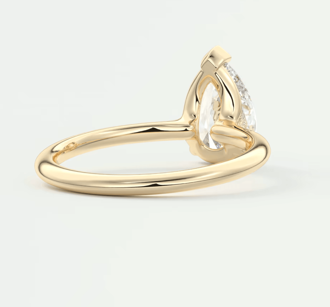 18k yellow gold engagement ring with a pear-shaped diamond and small accent diamonds.