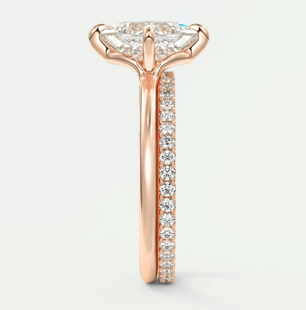 18k rose gold engagement ring with marquise diamond center stone and pavé diamonds on band.