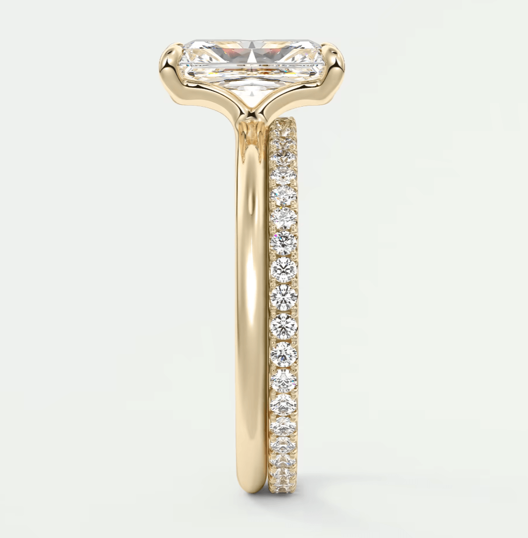 18k yellow gold engagement ring with a princess cut diamond and pave set diamonds on the band.